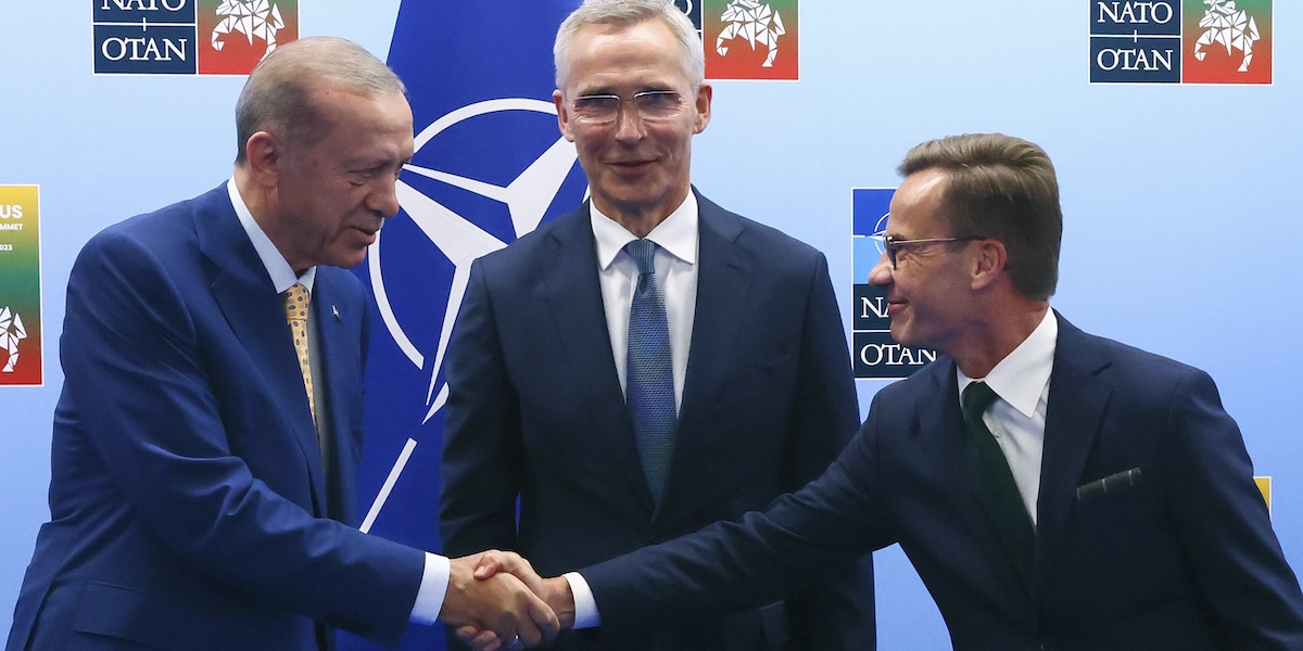 Il presidente turco Recep Tayyip Erdogan stringe la mano al primo ministro svedese Ulf Kristersson di fronte al segretario generale della NATO Jens Stoltenberg