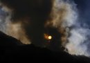 Il sole che sorge dietro alla collina di El Cable, mentre è in corso un incendio
