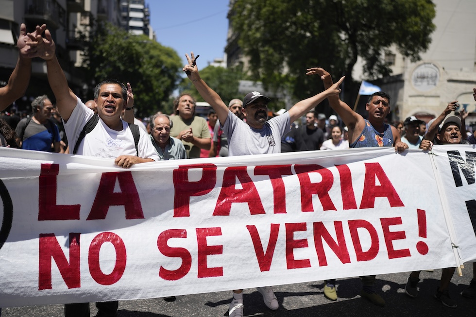 Manifestanti con un cartello che dice "La patria non si vende"