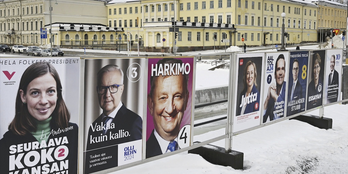 Poster dei candidati alle elezioni presidenziali con dietro dei palazzi gialli e la neve in terra
