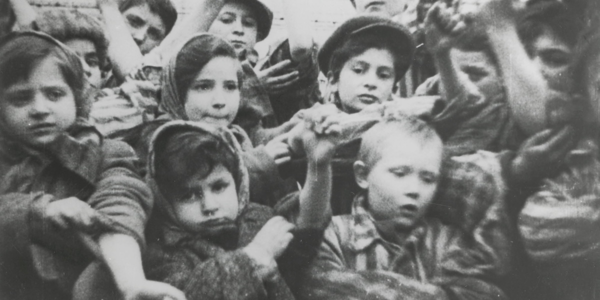 Bambini rinchiusi nel campo di concentramento e sterminio nazista di Auschwitz-Birkenau mostrano i loro numeri tatuati sulle braccia dopo la liberazione