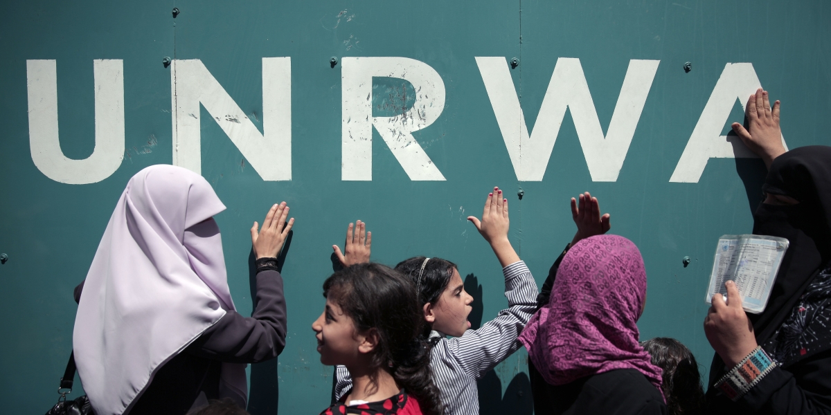 donne e bambini palestinesi davanti alla sede dell'UNRWA a Gaza