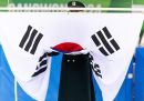 Una guardia che regge la bandiera nazionale della Corea del Sud durante la cerimonia di premiazione del pattinaggio artistico maschile ai Giochi olimpici giovanili invernali di Gangwon