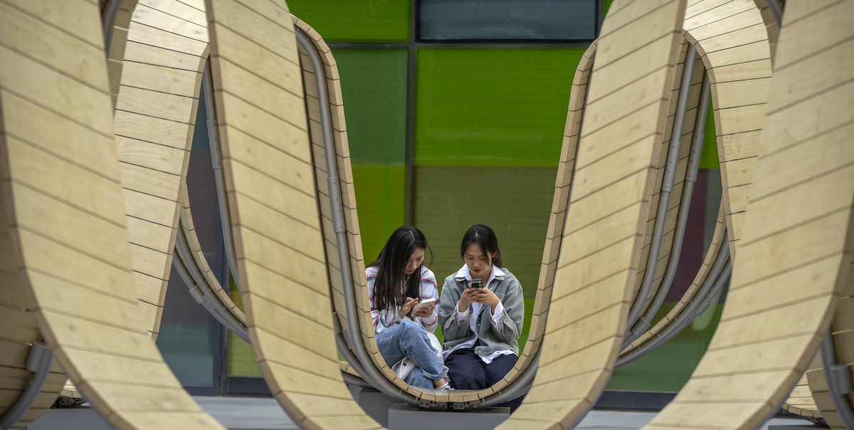 Due donne usano il proprio smartphone a Pechino, Cina