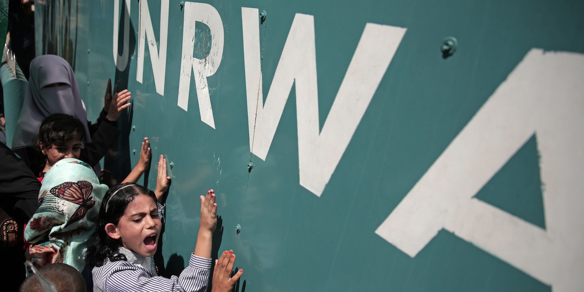 Bambini palestinesi davanti alla scritta UNRWA durante una manifestazione contro un'altra sospensione dei finanziamenti avvenuta nel 2015