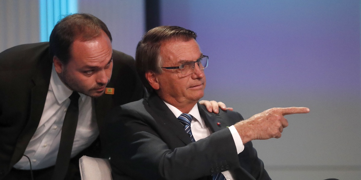 L'ex presidente brasiliano Jair Bolsonaro (seduto) con il figlio Carlos Bolsonaro, nel 2022 (AP Photo/Bruna Prado)