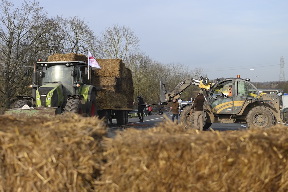 Agricoltori dispongono balle di fieno su un'autostrada a Roissy-en-France, vicino a Parigi