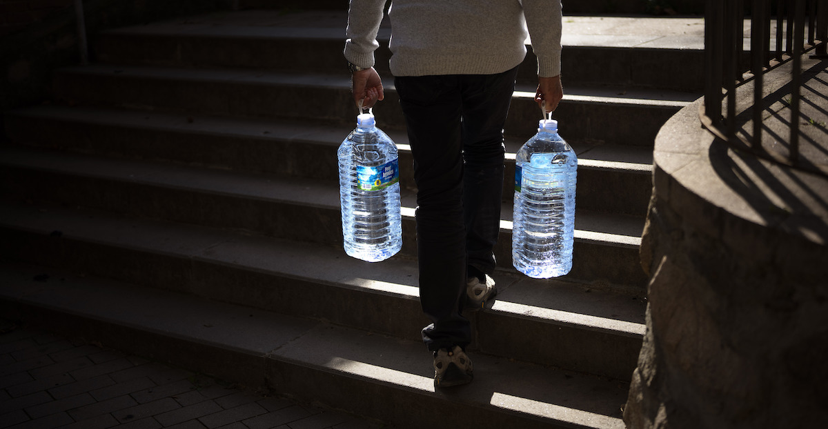 Un uomo trasporta bottiglie d'acqua a Gualba, un paese a 50 chilometri da Barcellona