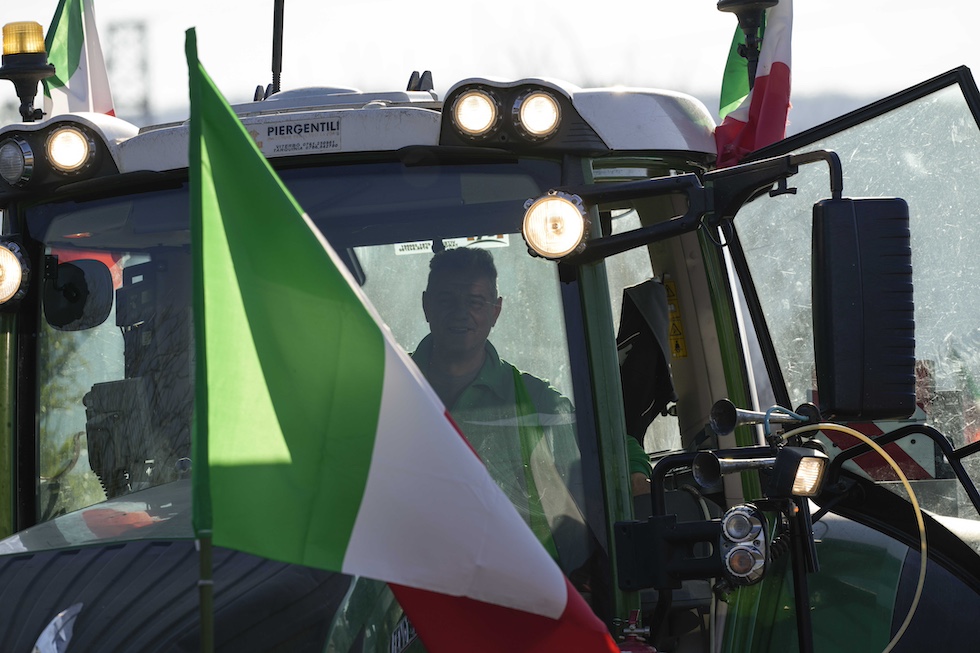 Agricoltore su un trattore con una bandiera dell'Italia