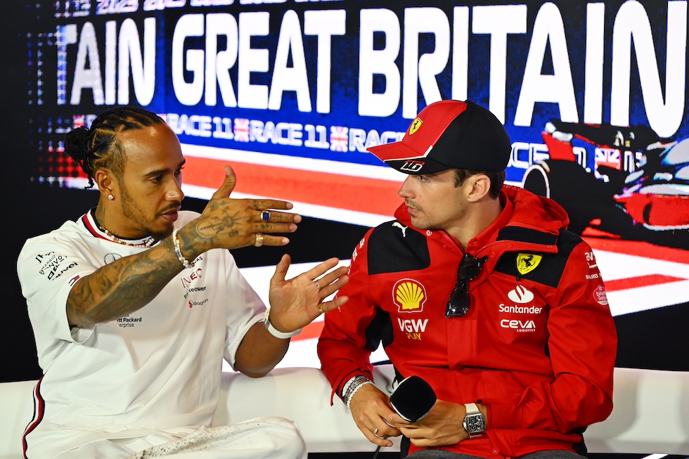 Hamilton e Leclerc parlano tra loro durante una conferenza stampa, seduti su un divano