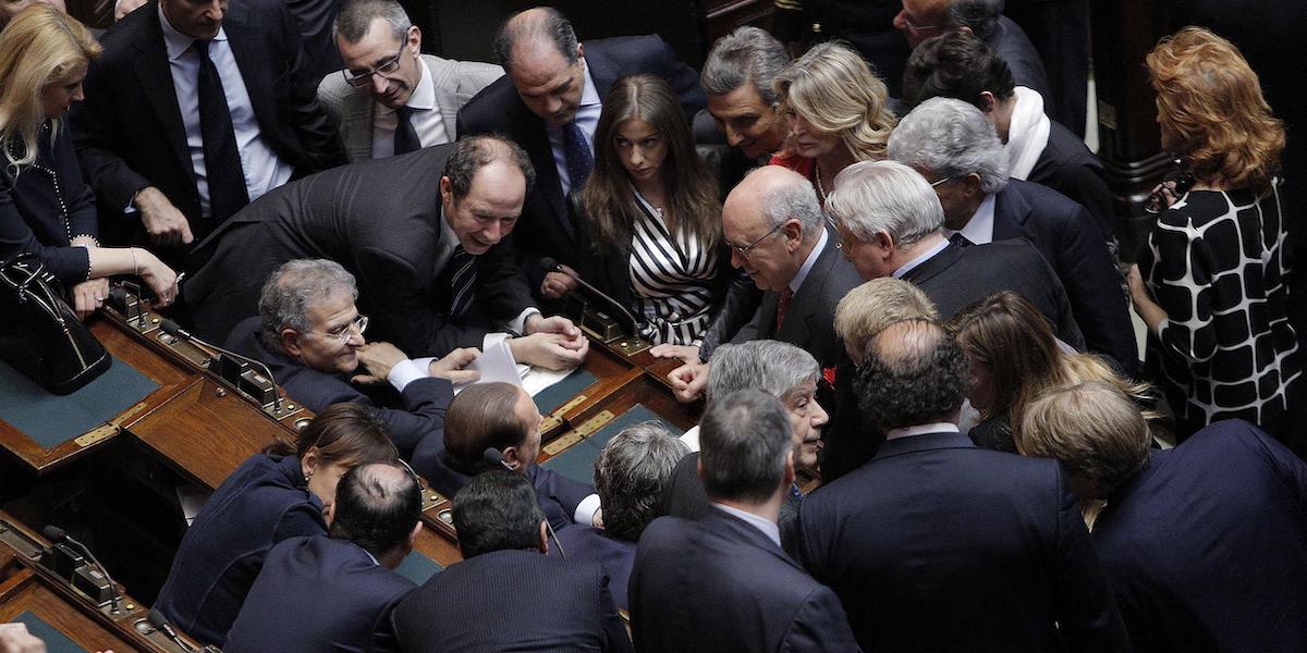 Parlamentari del Popolo della Libertà intorno a Berlusconi, alla Camera nel 2013 (Ansa)