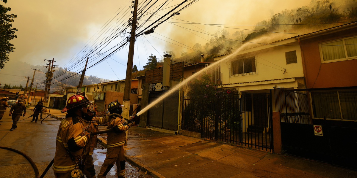 Vigili del fuoco sparano acqua su una casa in Cile per spegnere le fiamme