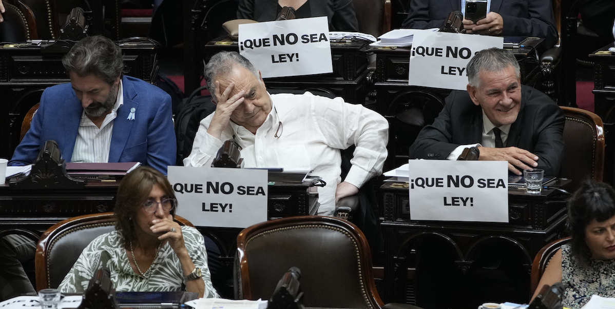 Cartelli in parlamento contro il disegno di legge omnibus proposto da Milei, Buenos Aires, Argentina, 2 febbraio 2024 (AP Photo/Natacha Pisarenko)