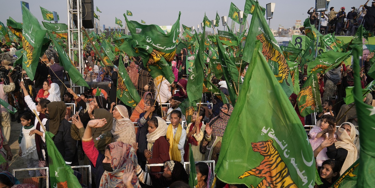 Elettori del partito dell'ex primo ministro Nawaz Sharif durante un comizio elettorale a Khudian Khas, in Punjab con bandiere verdi con una tigre al centro, simbolo del partito