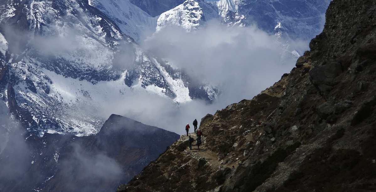 Escursionisti camminano di fronte al Monte Thamserku mentre tornano dal campo base dell'Everest (REUTERS/Navesh Chitrakar)