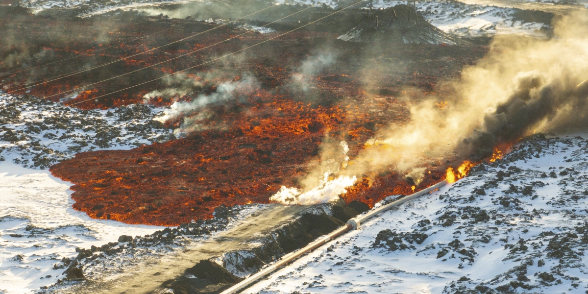 lava che supera una barriera protettiva e danneggia un tubo dell'acqua