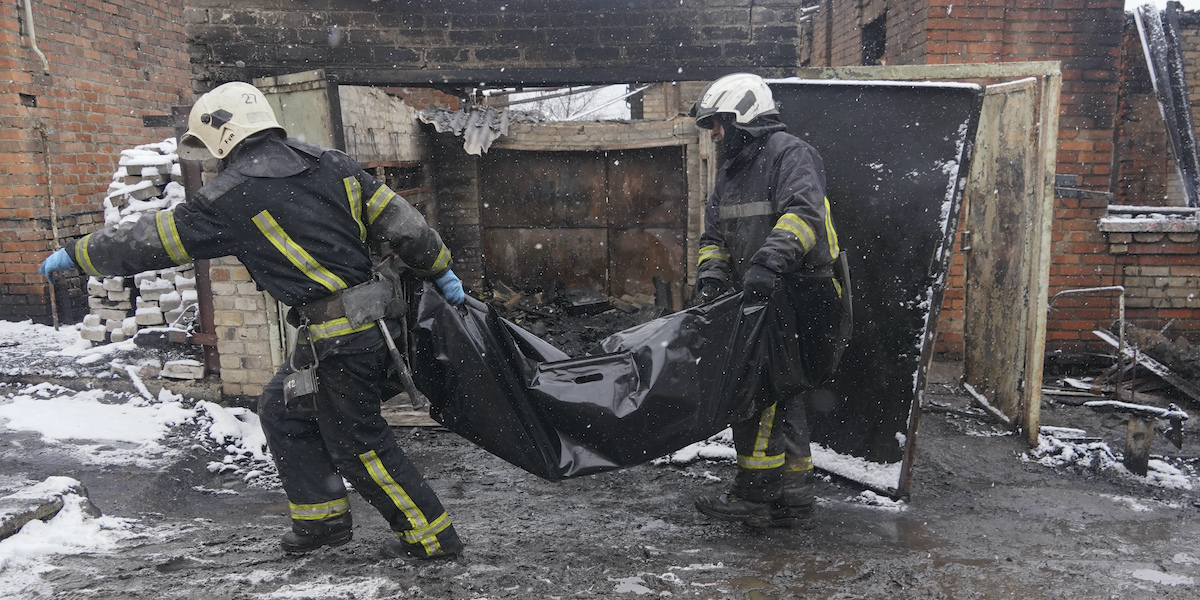 I vigili del fuoco trasportano il corpo di una delle persone uccise nel bombardamento (AP Photo/Andrii Marienko)