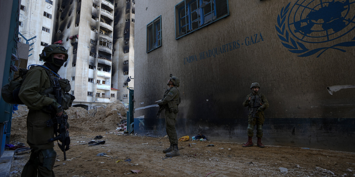 Soldati israeliani davanti alla sede dell'UNRWA nella città di Gaza (AP Photo/Ariel Schalit)