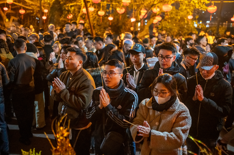 Un gruppo di persone prega al tempio Tay Ho per celebrare l'inizio del Capodanno lunare