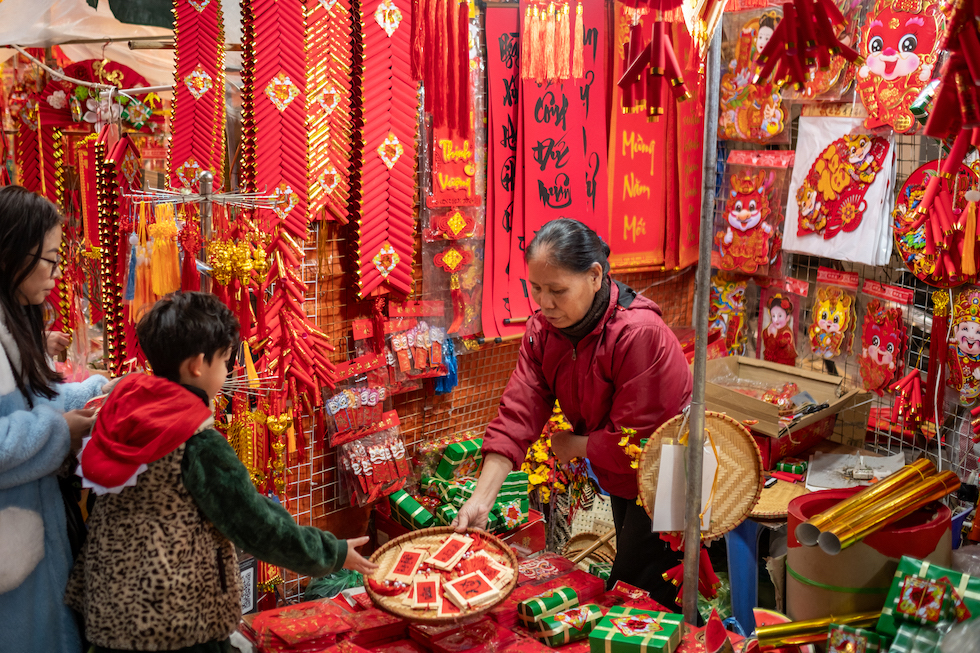 Un bambino acquista alcune decorazioni tradizionali per il Capodanno lunare