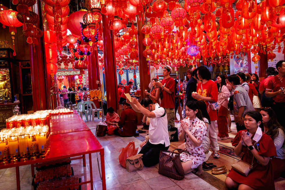 Un gruppo di persone prega al tempio Wat Mangkon alla vigilia del Capodanno lunare