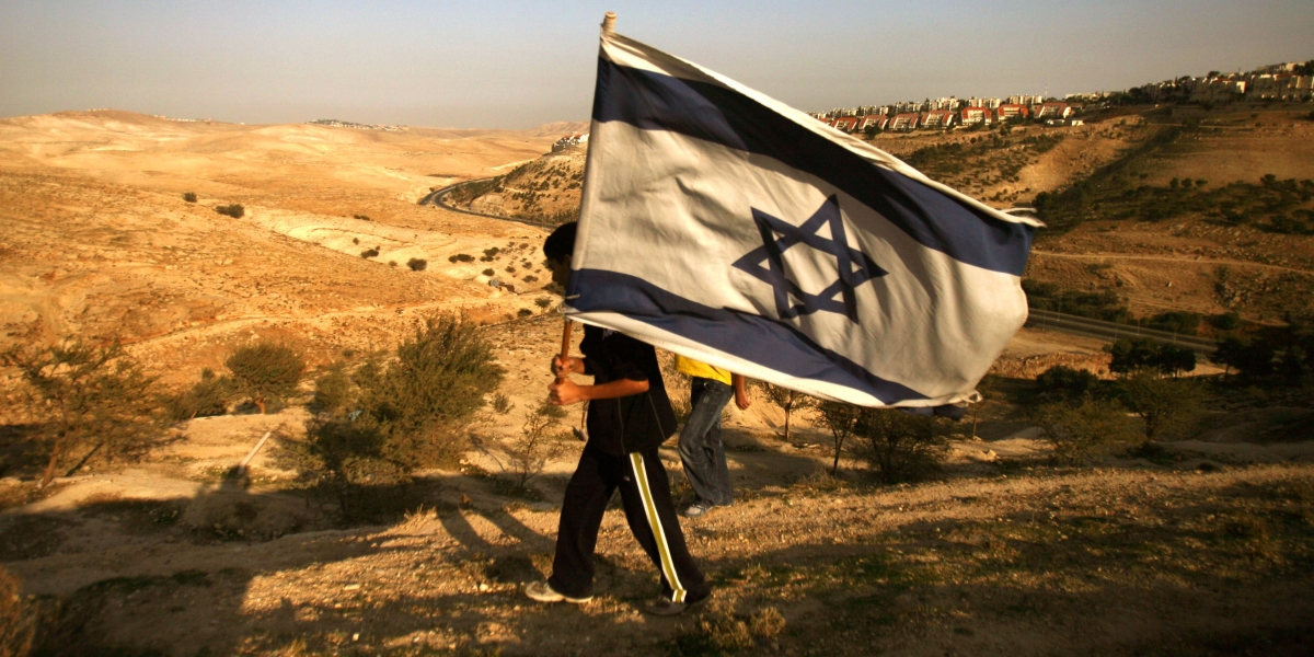 una persona con una grande bandiera di israele