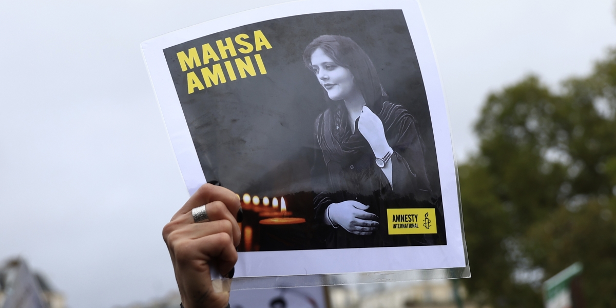 Un cartello con la foto di Mahsa Amini durante una manifestazione a Parigi