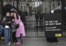 Quattro persone si scattano un selfie mentre un attivista di Amnesty International mostra un cartello di protesta contro gli attacchi israeliani nella Striscia di Gaza fuori da Downing street, la residenza del primo ministro britannico (Londra, Inghilterra)
