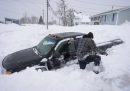Un uomo cerca di liberare la neve accumulata attorno al suo pick-up dopo una nevicata in Nuova Scozia (Sydney, Canada)