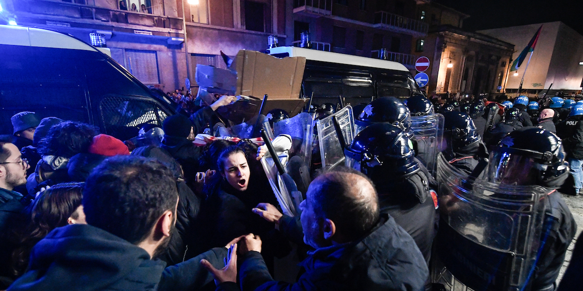 Foto di manifestanti che si scontrano con la polizia in assetto anti-sommossa