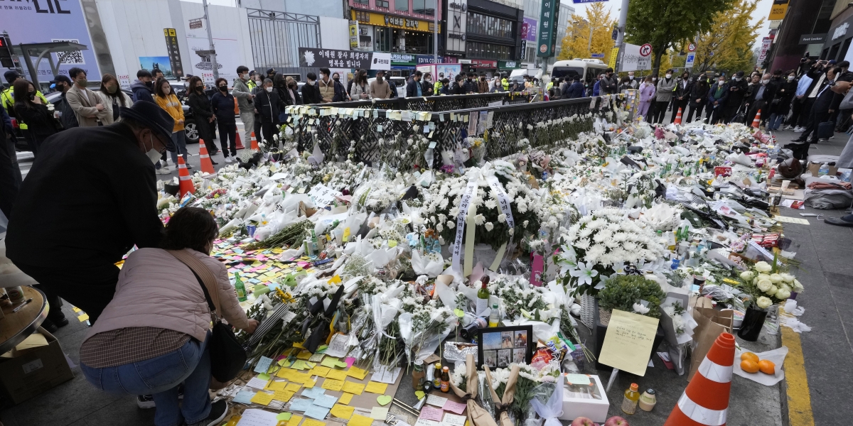 persone lasciano fiori e biglietti vicino al luogo in cui è avvenuta la strage