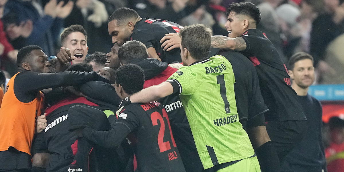 I giocatori del Bayer Leverkusen che esultano dopo il gol del 3-0 contro il Bayern Monaco, e Xabi Alonso che li guarda sullo sfondo