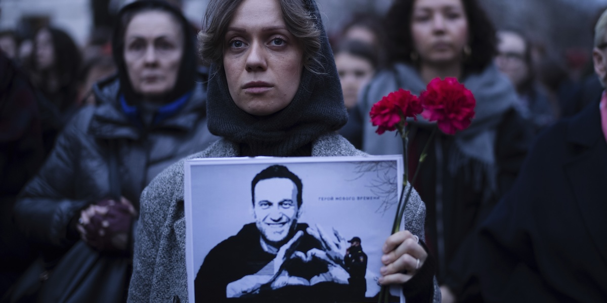 Una donna con una foto di Alexei Navalny davanti all'ambasciata russa a Berlino, in Germania