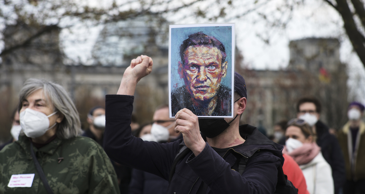 Un uomo con un ritratto di Navalny durante una manifestazione in Germania