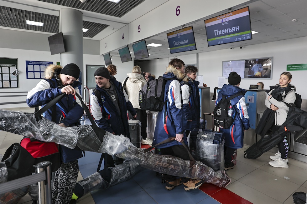 Un gruppo di ragazzi russi spediscono i loro sci al banco del check-in all'aeroporto internazionale di Vladivostok, in Russia, prima di imbarcarsi per la Corea del Nord (AP Photo)