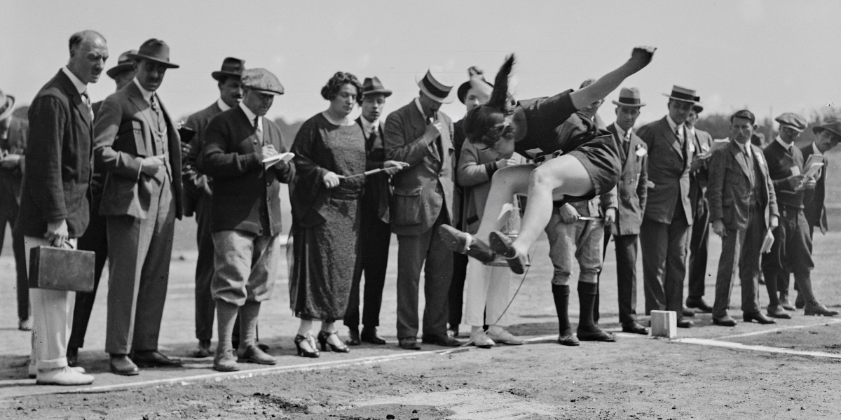 Un'atleta cecoslovacca durante la gara di salto in lungo ai Giochi olimpici femminili del 1922. La donna al centro del gruppo che guarda il salto è Alice Milliat (Central Press/Hulton Archive/Getty Images)