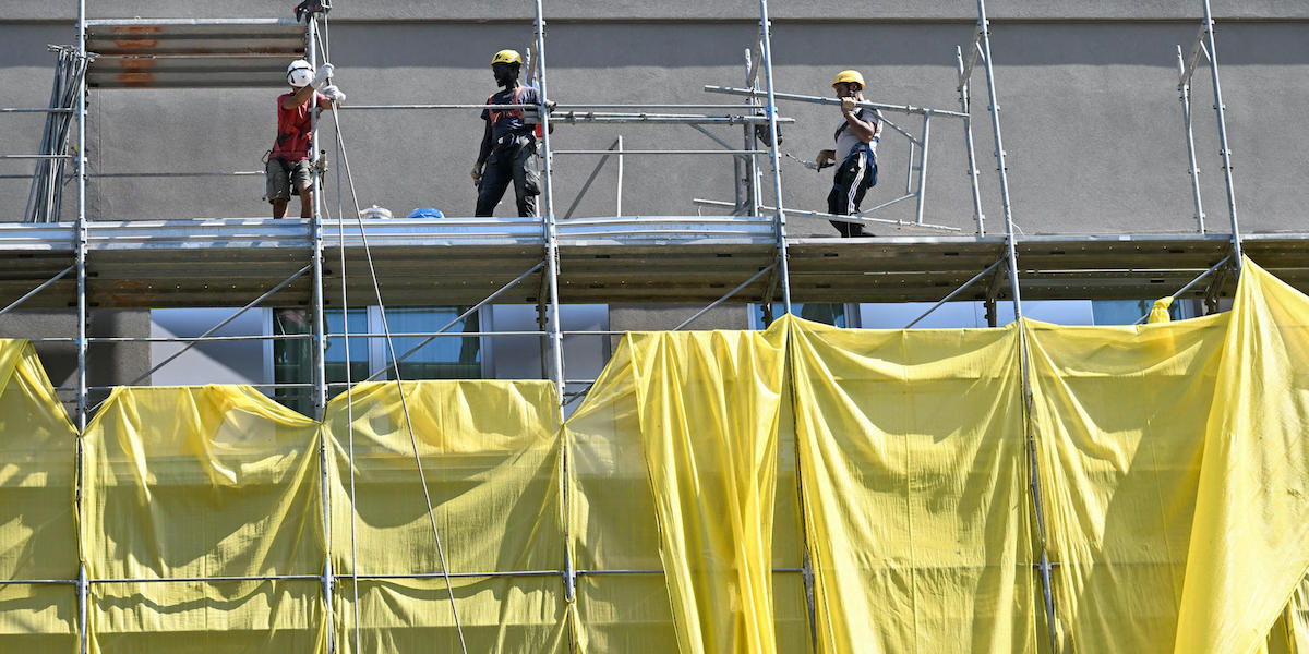 Operai sulla facciata di un edificio a Milano