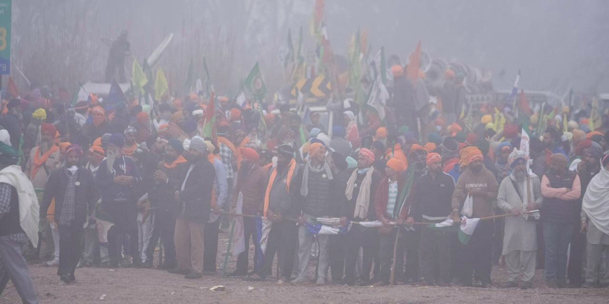 un gruppo di manifestanti con turbanti colorati avvolti dalla nebbia e dal fumo