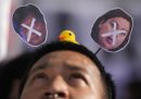 Un uomo indossa un cerchietto con delle croci disegnate sulle facce del presidente filippino Ferdinand Marcos Jr. e della vicepresidente Sara Duterte durante una protesta contro la proposta di modifica di alcune parti della Costituzione del paese