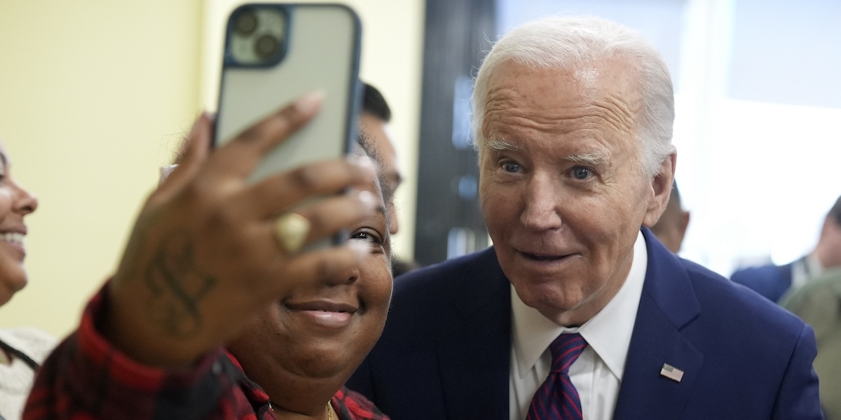 Joe Biden si fa un selfie con una donna durante una visita a Los Angeles, mercoledì 21 febbraio