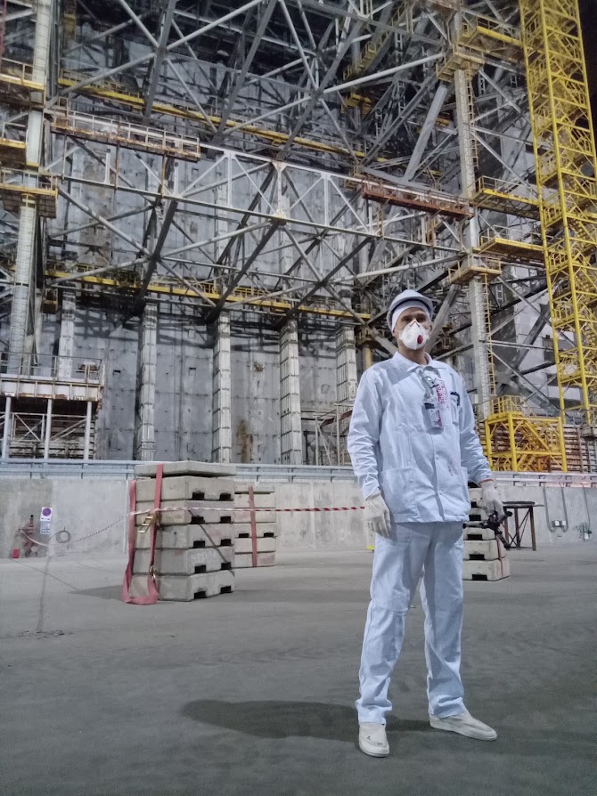 Un lavoratore della centrale di Chernobyl di fronte alla struttura di contenimento del reattore numero 4 