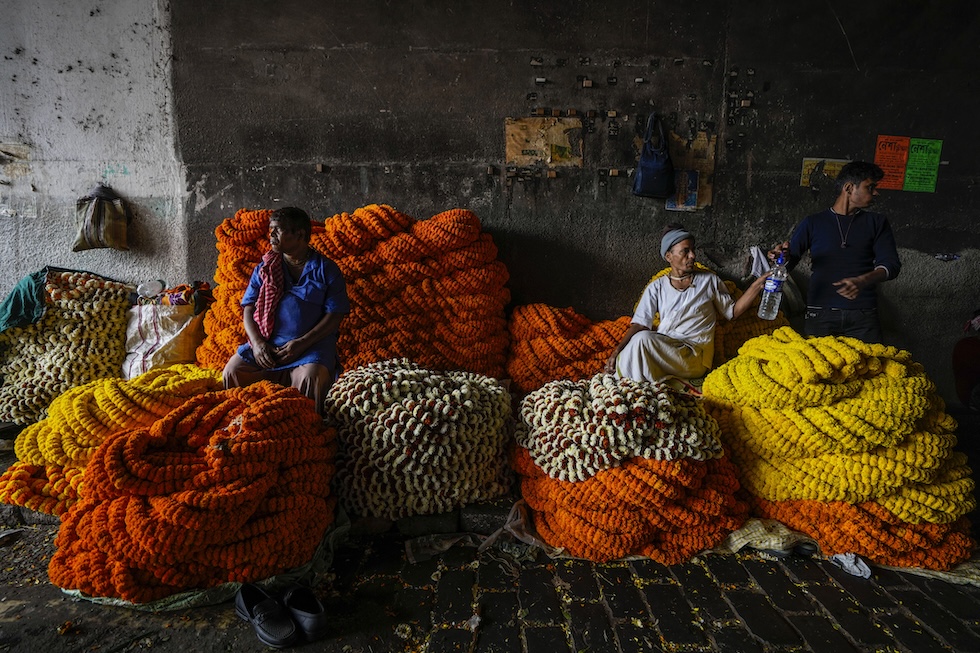 Venditori di ghirlande di calendule in un mercato di fiori