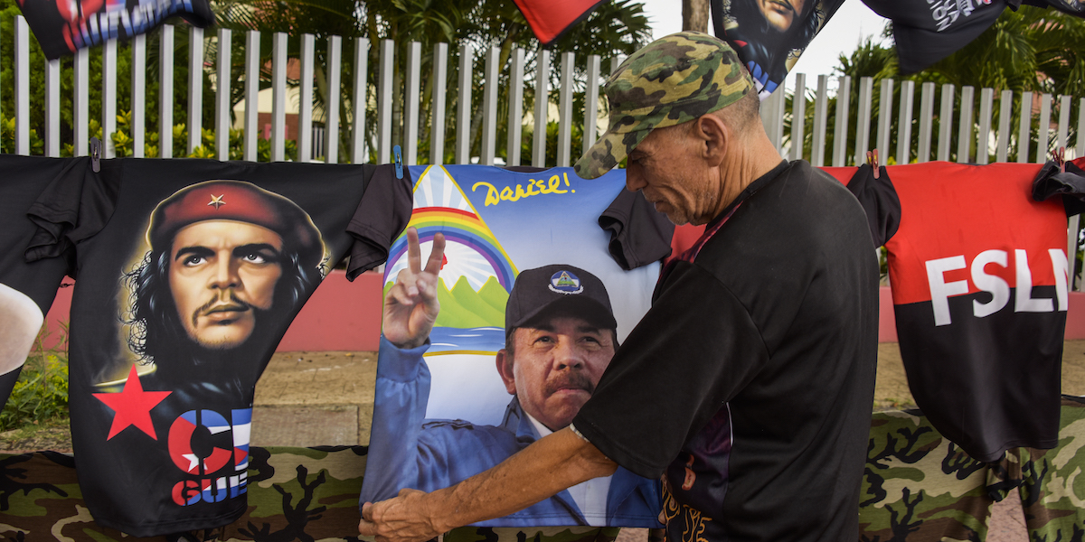 Un uomo appende delle magliette con i volti del presidente nicaraguense Daniel Ortega e di altri leader centramericani (Getty Images)