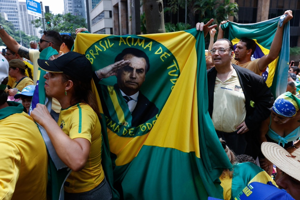 Una bandiera del Brasile con la faccia di bolsonaro al centro