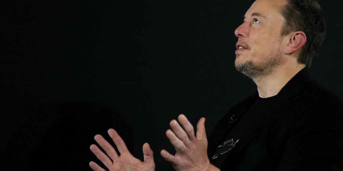 Elon Musk con le mani e lo sguardo rivolti al cielo