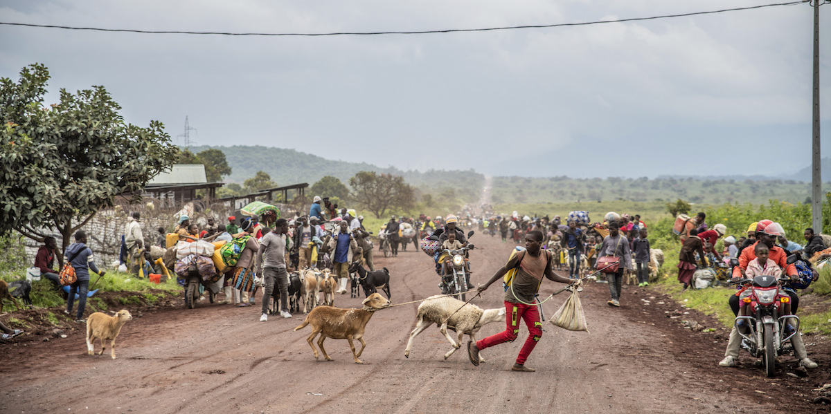 Persone lungo la strada di Kibumba, a nord di Goma, mentre scappano dai combattimenti tra le forze congolesi e i ribelli dell'M23 nel Nord Kivu, 24 maggio 2022 (AP Photo/Moses Sawasawa, File)