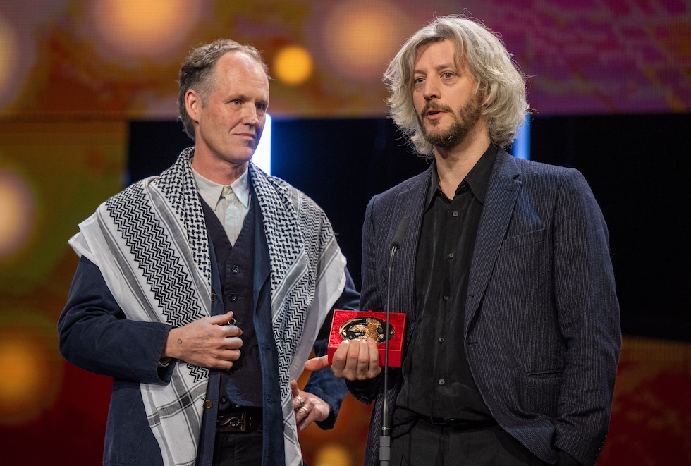 Guillaume Cailleau (a destra) e Ben Russell (a sinistra) con addosso una kefiah ricevono il premio di miglior film per la giuria Encounters (Monika Skolimowska/dpa)