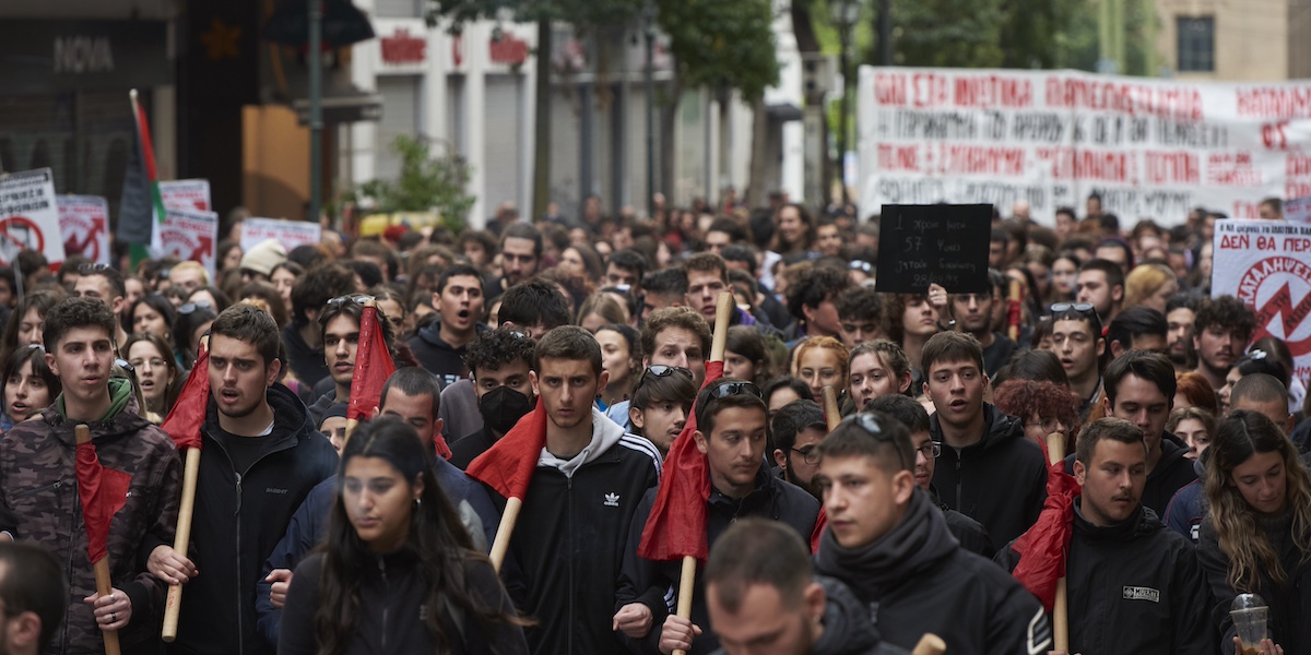 La manifestazione ad Atene di mercoledì 28 febbraio 2024. In prima fila ci sono dei giovani, probabilmente studenti, con delle bandiere rosse