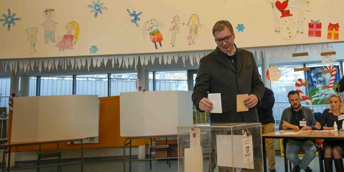 Aleksandar Vučić che inserisce una scheda in un'urna trasparente in una scuola