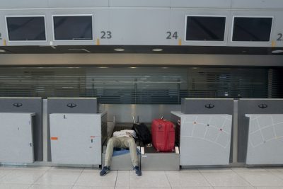 Un passeggero riposa in un'area check-in dopo che il suo volo è stato sospeso per uno sciopero, all'aeroporto di Ezeiza